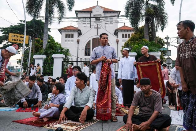 Muslim devotees prepare to attend Eid al-Fitr prayers, marking the end of the holy month of Ramadan, in Jakarta on March 21, 2026. (Photo by BAY ISMOYO / AFP)