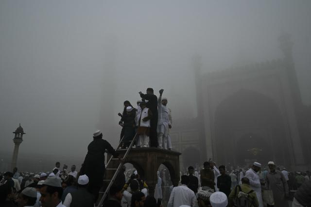 Muslim devotees celebrate after offering prayers, marking the end of the holy month of Ramadan, at Jama Masjid in the old quarters of new Delhi on March 21, 2026. (Photo by Arun SANKAR / AFP)