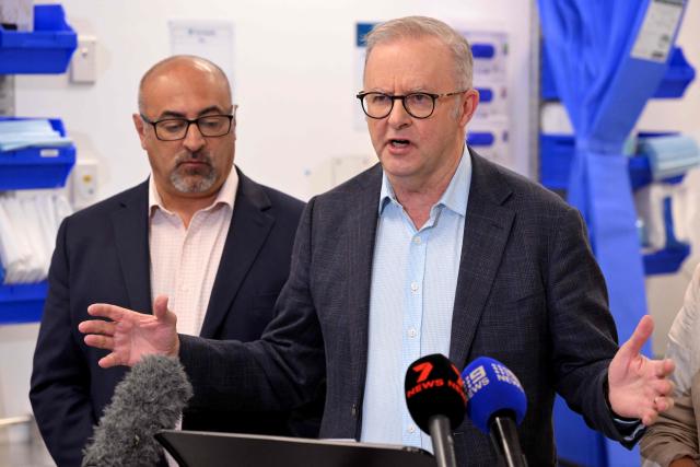 Australia's Prime Minister Anthony Albanese (R) speaks  as local member of parliament Peter Khalil (L) looks on during a press conference after the opening of a medical centre in the Melbourne suburb of Coburg on March 21, 2026. Albanese answered questions relating to the fuel crisis and comments by US President Trump. (Photo by William WEST / AFP)