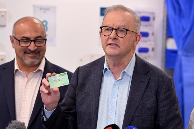 Australia's Prime Minister Anthony Albanese (R) speaks  as local member of parliament Peter Khalil (L) looks on during a press conference after the opening of a medical centre in the Melbourne suburb of Coburg on March 21, 2026. Albanese answered questions relating to the fuel crisis and comments by US President Trump. (Photo by William WEST / AFP)