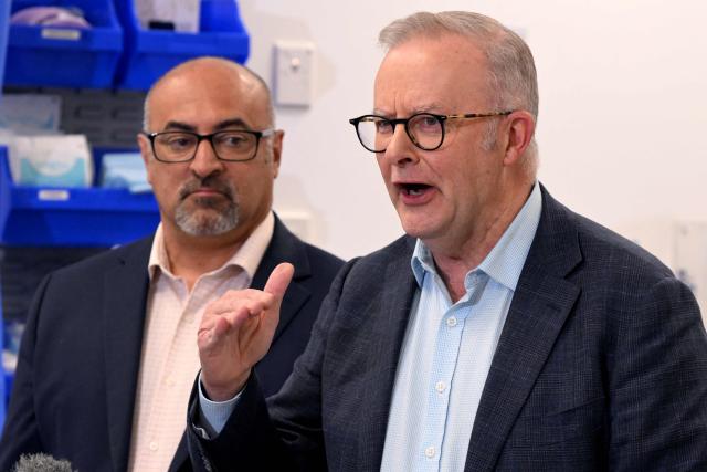 Australia's Prime Minister Anthony Albanese (R) speaks  as local member of parliament Peter Khalil (L) looks on during a press conference after the opening of a medical centre in the Melbourne suburb of Coburg on March 21, 2026. Albanese answered questions relating to the fuel crisis and comments by US President Trump. (Photo by William WEST / AFP)