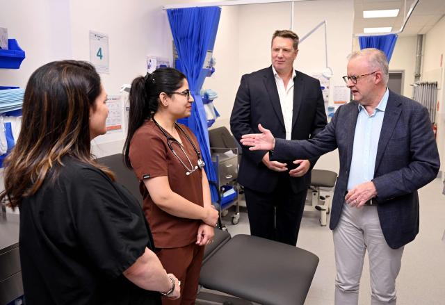 Australia's Prime Minister Anthony Albanese (R) speaks to staff during the opening of a medical centre in the Melbourne suburb of Coburg on March 21, 2026. Albanese answered questions relating to the fuel crisis and comments by US President Trump. (Photo by William WEST / AFP)