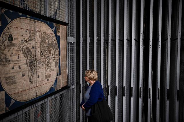 (FILES) A journalist looks at an old map display in storage reserves during a press visit to the Maps and Plans Department of the Bibliothèque nationale de France (BnF) in Paris, on January 8, 2026. The exhibition "Cartes imaginaires" (Imaginary Maps), which explores the links between between cartography and the imagination, runs from March 24, to July 19, 2026, at the Bibliotheque nationale de France (BnF). (Photo by JULIEN DE ROSA / AFP)
