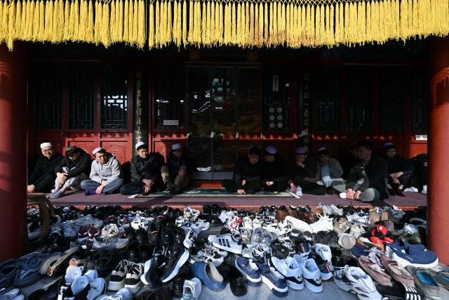 Muslim devotees offer prayers during Eid Al-Fitr, which marks the end of the Islamic holy fasting month of Ramadan, at a mosque in Beijing on March 21, 2026. (Photo by ADEK BERRY / AFP)