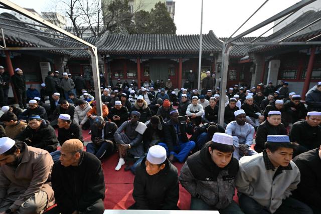 Muslim devotees offer prayers during Eid Al-Fitr, which marks the end of the Islamic holy fasting month of Ramadan, at a mosque in Beijing on March 21, 2026. (Photo by ADEK BERRY / AFP)