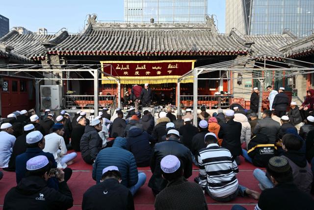 Muslim devotees offer prayers during Eid Al-Fitr, which marks the end of the Islamic holy fasting month of Ramadan, at a mosque in Beijing on March 21, 2026. (Photo by ADEK BERRY / AFP)