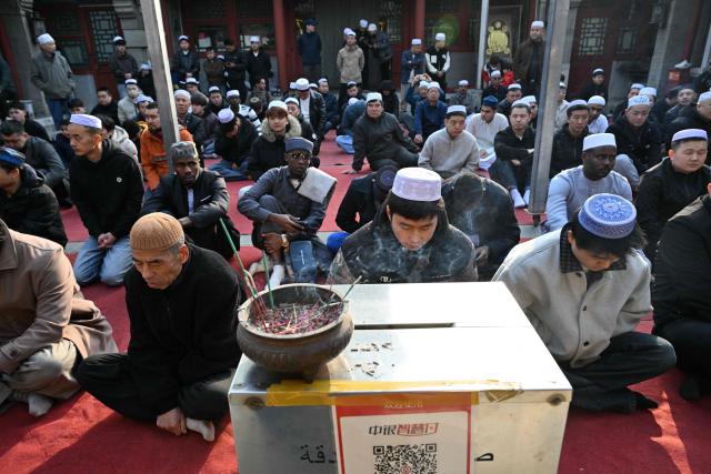Muslim devotees prepare for the Eid Al-Fitr prayers celebrations, which marks the end of the Islamic holy fasting month of Ramadan, at a mosque in Beijing on March 21, 2026. (Photo by ADEK BERRY / AFP)