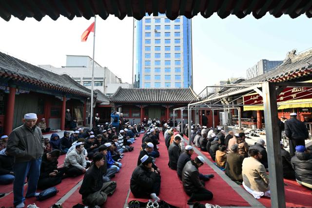 Muslim devotees prepare for the Eid Al-Fitr prayers, which marks the end of the Islamic holy fasting month of Ramadan, at a mosque in Beijing on March 21, 2026. (Photo by ADEK BERRY / AFP)