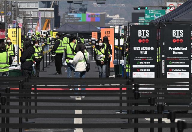 Staff members prepare at the venue of the comeback concert of K-pop boy group BTS in downtown Seoul on March 21, 2026. The world's biggest boy band BTS reunites on March 21, for an open-air comeback concert in the heart of Seoul, expected to draw around 250,000 people and beamed live across the globe. (Photo by Jung Yeon-je / AFP)