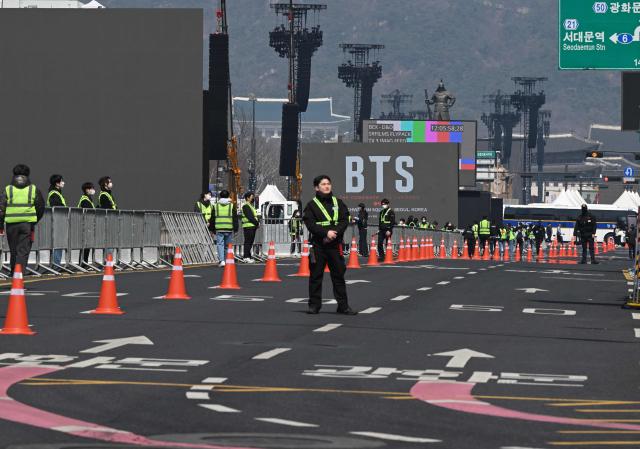 Staff members prepare at the venue of the comeback concert of K-pop boy group BTS in downtown Seoul on March 21, 2026. The world's biggest boy band BTS reunites on March 21, for an open-air comeback concert in the heart of Seoul, expected to draw around 250,000 people and beamed live across the globe. (Photo by Jung Yeon-je / AFP)