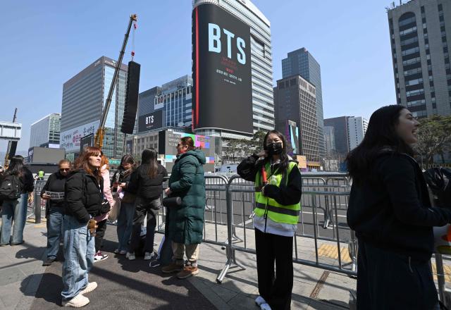 BTS fans arrive at the venue of the comeback concert of K-pop boy group BTS in downtown Seoul on March 21, 2026. The world's biggest boy band BTS reunites on March 21, for an open-air comeback concert in the heart of Seoul, expected to draw around 250,000 people and beamed live across the globe. (Photo by Jung Yeon-je / AFP)