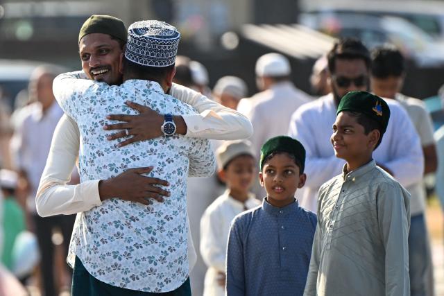 Muslim devotees hug each other after offering Eid al-Fitr prayers, which marks the end of the Islamic holy fasting month of Ramadan, at Galle Face in Colombo on March 21, 2026. (Photo by Ishara S. KODIKARA / AFP)