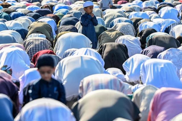 A child looks on as Muslim devotees offer Eid al-Fitr prayers, which marks the end of the Islamic holy fasting month of Ramadan, at Galle Face in Colombo on March 21, 2026. (Photo by Ishara S. KODIKARA / AFP)