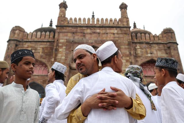 Muslim devotees hug each other after offering Eid al-Fitr prayers, which marks the end of the Islamic holy fasting month of Ramadan, at Alamgir Mosque along the banks of the river Ganges in Varanasi on March 21, 2026. (Photo by Niharika KULKARNI / AFP)