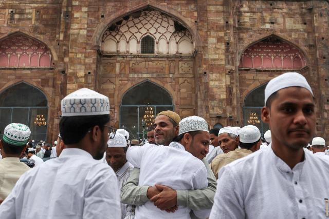 Muslim devotees hug each other after offering Eid al-Fitr prayers, which marks the end of the Islamic holy fasting month of Ramadan, at Alamgir Mosque along the banks of the river Ganges in Varanasi on March 21, 2026. (Photo by Niharika KULKARNI / AFP)
