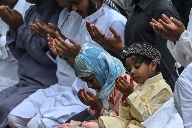 Muslim devotees offer Eid al-Fitr prayers, which marks the end of the Islamic holy fasting month of Ramadan, amid rainfall in Kolkata on March 21, 2026. (Photo by Dibyangshu SARKAR / AFP)