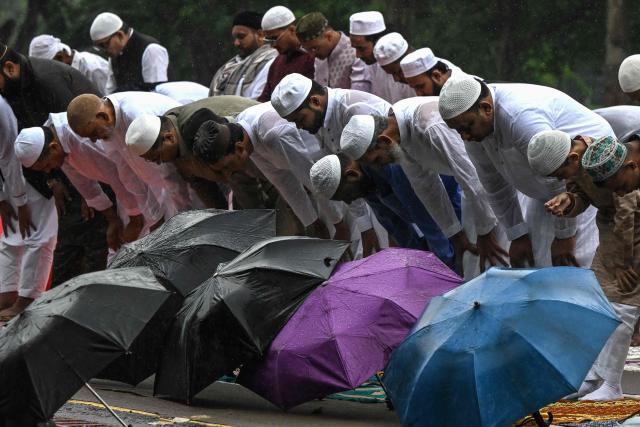 Muslim devotees offer Eid al-Fitr prayers, which marks the end of the Islamic holy fasting month of Ramadan, amid rainfall in Kolkata on March 21, 2026. (Photo by Dibyangshu SARKAR / AFP)