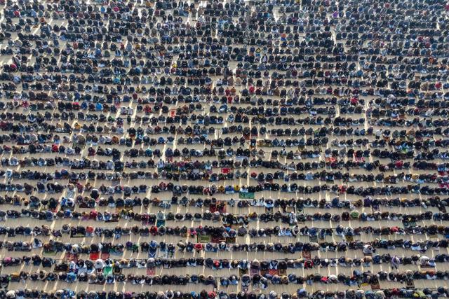 An aerial view shows Shia Muslims offering Eid al-Fitr prayers, which marks the end of the Islamic holy fasting month of Ramadan, in Skardu, Pakistan's Gilgit-Baltistan, on March 21, 2026. (Photo by Manzoor BALTI / AFP)