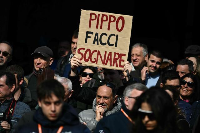 A supporter of Ineos Grenadiers' Italian rider Filippo Ganna holds a placard reading "Pippo make us dream" before the Milan - Sanremo one-day classic cycling race, in Pavia, on March 21, 2026. (Photo by Marco BERTORELLO / AFP)
