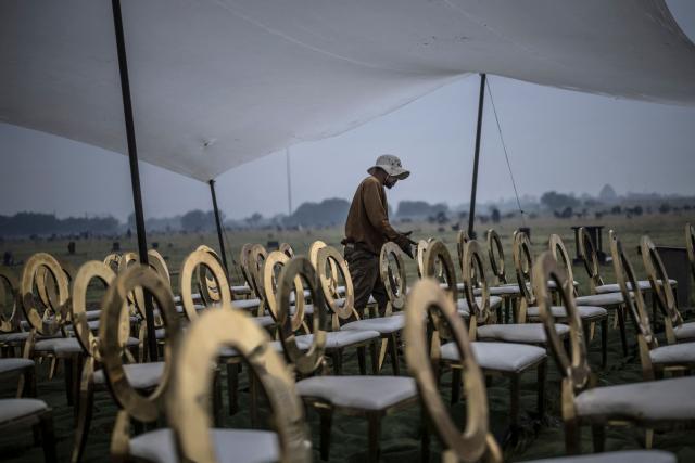 A member of the protocol adjusts chairs ahead of a ceremony commemorating the dozens killed on March 21, 1960 during what is remembered as the Sharpeville Massacre, at the Phelindaba Cemetery in Sharpeville, on March 21, 2026. The Sharpeville massacre occurred on 21 March 1960, when police opened fire on a crowd of people who had assembled outside the police station in the township of Sharpeville in the then Transvaal Province of the then Union of South Africa (today part of Gauteng) to protest against the pass laws. Today South Africa remembers the victims in what has become Human Rights Day. (Photo by MARCO LONGARI / AFP)