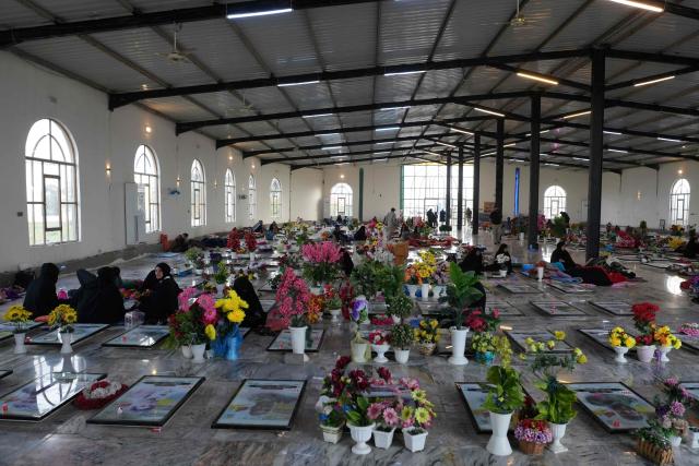 Iraqi Shias visit graves of relatives at the pro-Iranian armed group Kataeb Hezbollah Cemetery in Iraq's central holy city of Najaf as they remember the deceased as well as victims of wars on Eid al-Fitr, marking the end of the fasting month of Ramadan, on March 21, 2026. Iraq has been unwillingly drawn into the regional conflict triggered by the US-Israel attack on its neighbour Iran on February 28. Strikes have targeted Iran-backed groups, which in turn have claimed near-daily attacks on US interests, mostly in Iraq but also across the wider region. (Photo by AFP)