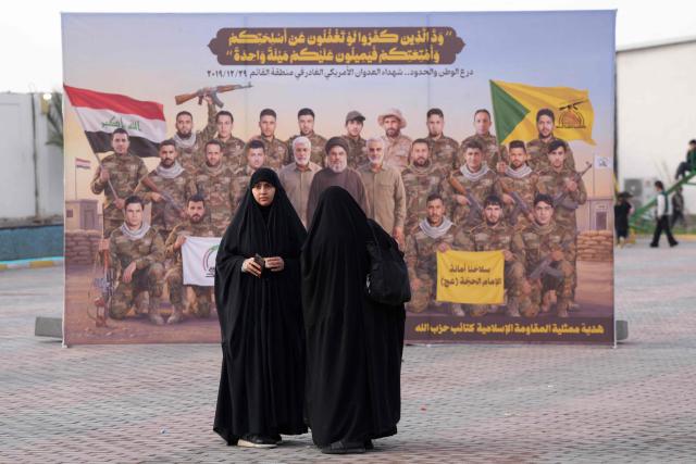 Shia women visit the pro-Iranian armed group Kataeb Hezbollah Cemetery in Iraq's central holy city of Najaf as they remember the deceased as well as victims of wars on Eid al-Fitr, marking the end of the fasting month of Ramadan, on March 21, 2026. Iraq has been unwillingly drawn into the regional conflict triggered by the US-Israel attack on its neighbour Iran on February 28. Strikes have targeted Iran-backed groups, which in turn have claimed near-daily attacks on US interests, mostly in Iraq but also across the wider region. (Photo by Qassem al-KAABI / AFP)