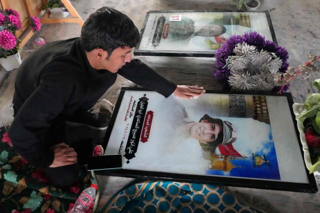 An Iraqi Shia visits a grave at the pro-Iranian armed group Kataeb Hezbollah Cemetery in Iraq's central holy city of Najaf as they remember the deceased as well as victims of wars on Eid al-Fitr, marking the end of the fasting month of Ramadan, on March 21, 2026. Iraq has been unwillingly drawn into the regional conflict triggered by the US-Israel attack on its neighbour Iran on February 28. Strikes have targeted Iran-backed groups, which in turn have claimed near-daily attacks on US interests, mostly in Iraq but also across the wider region. (Photo by AFP)