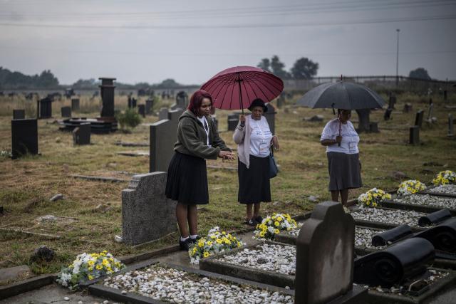 A woman motions as she whispers a prayer on the grave of a relative during the commemorations of the dozens killed on March 21, 1960 during what is remembered as the Sharpeville Massacre, at the Phelindaba Cemetery in Sharpeville, on March 21, 2026. The Sharpeville massacre occurred on 21 March 1960, when police opened fire on a crowd of people who had assembled outside the police station in the township of Sharpeville in the then Transvaal Province of the then Union of South Africa (today part of Gauteng) to protest against the pass laws. Today South Africa remembers the victims in what has become Human Rights Day. (Photo by MARCO LONGARI / AFP)
