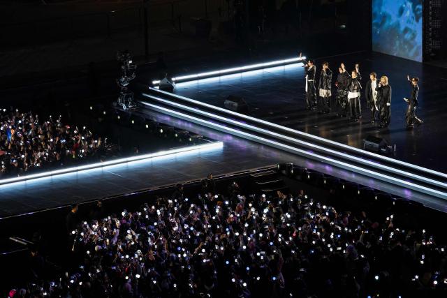 K-pop boy group BTS wave to fans after performing during their concert at Gwanghwamun Square in Seoul on March 21, 2026. South Korean megastars BTS reunite on March 21, for their first show in nearly four years, with an expected 260,000 fans taking over central Seoul for a K-pop extravaganza livestreamed to millions more worldwide. (Photo by Kim Hong-Ji / POOL / AFP)
