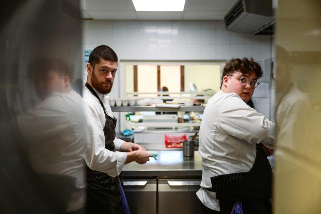 Cooks work in the kitchen at the restaurant Les Morainieres, whose French chef Michael Arnoult has just been awarded a third Michelin star, in Jongieux, central-eastern France, on March 20, 2026. The calm amid the vineyards of Jongieux in Savoie contrasts with the bustle of the restaurant Les Morainières, where chef Michael Arnoult received no fewer than 250 reservations as soon as his third Michelin star was awarded. (Photo by OLIVIER CHASSIGNOLE / AFP)