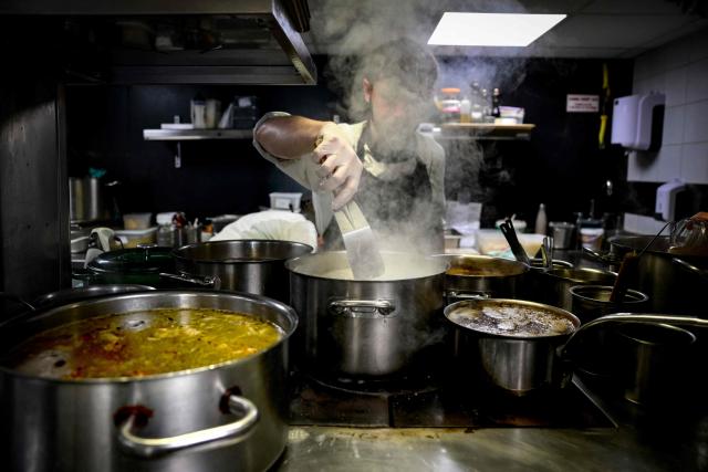 A cook works in the kitchen at the restaurant Les Morainieres, whose French chef Michael Arnoult has just been awarded a third Michelin star, in Jongieux, central-eastern France, on March 20, 2026. The calm amid the vineyards of Jongieux in Savoie contrasts with the bustle of the restaurant Les Morainières, where chef Michael Arnoult received no fewer than 250 reservations as soon as his third Michelin star was awarded. (Photo by OLIVIER CHASSIGNOLE / AFP)