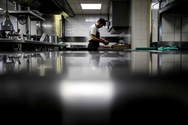 A cook works in the kitchen at the restaurant Les Morainieres, whose French chef Michael Arnoult has just been awarded a third Michelin star, in Jongieux, central-eastern France, on March 20, 2026. The calm amid the vineyards of Jongieux in Savoie contrasts with the bustle of the restaurant Les Morainières, where chef Michael Arnoult received no fewer than 250 reservations as soon as his third Michelin star was awarded. (Photo by OLIVIER CHASSIGNOLE / AFP)