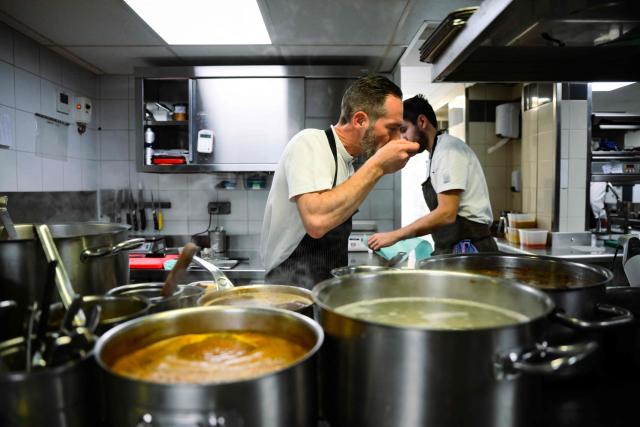 French chef Michael Arnoult, who has just been awarded a third Michelin star, works in the kitchen at his restaurant Les Morainieres in Jongieux, central-eastern France, on March 20, 2026. The calm amid the vineyards of Jongieux in Savoie contrasts with the bustle of the restaurant Les Morainières, where chef Michael Arnoult received no fewer than 250 reservations as soon as his third Michelin star was awarded. (Photo by OLIVIER CHASSIGNOLE / AFP)