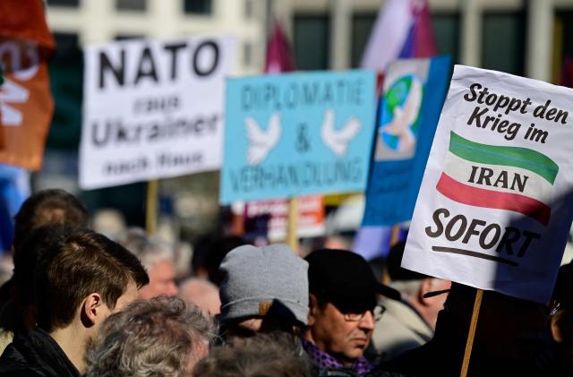 A protester holds up a placard reading "Stop the war in Iran" during a demonstration for peace titled "No to war against Iran! Peace instead of escalating conflict!" organised by the BSW (Bündnis Sahra Wagenknecht) party, on March 21, 2026 in Berlin. (Photo by John MACDOUGALL / AFP)