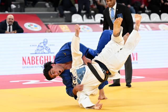 Turkey's Muhammed Demirel (white) competes against Georgia's Giorgi Loladze in the men's under 73 kg bronze medal bout at the Tbilisi Grand Slam judo tournament in Tbilisi on March 21, 2026. (Photo by Vano SHLAMOV / AFP)