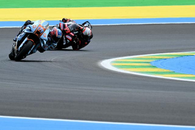Trackhouse MotoGP Team's Japanese rider Ai Ogura (L) and Aprilia Racing's Italian rider Marco Bezzecchi race during the MotoGP qualifying session of the Grand Prix of Brazil, at the Ayrton Senna International racetrack in Goiania, state of Goias, Brazil, on March 21, 2026. (Photo by EVARISTO SA / AFP)