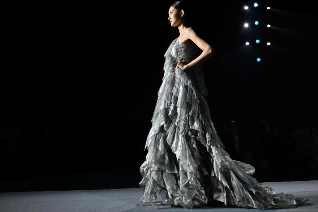 A model presents a creation by designers Gu Yuanyuan, Liang Yan and Wan Lan at the Beijing Fashion Week in Beijing on March 21, 2026. (Photo by ADEK BERRY / AFP)