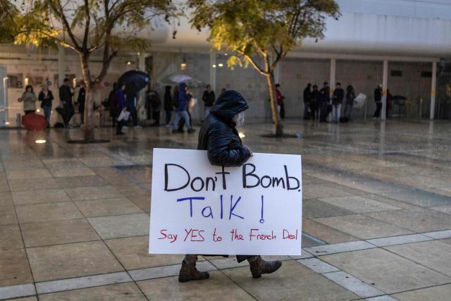 An Israeli left-wing activist carries a placard as he prepares to take part in a protest in Tel Aviv on March 21, 2026, against the ongoing war with Iran. The United States and Israel launched strikes against Iran on February 28, sparking swift retaliation by the Islamic republic which responded with missile attacks across the region. (Photo by Ilia YEFIMOVICH / AFP) / 