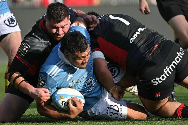 Perpignan's French hooker Sama Malolo (C) is tackled during the French Top 14 rugby union match between USA Perpignan and Lyon OU at the Aime-Giral stadium in Perpignan, south-western France, on March 21, 2026. (Photo by Matthieu RONDEL / AFP)