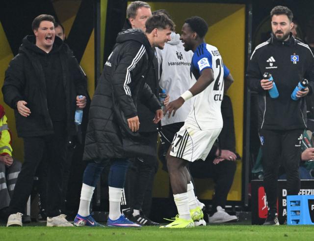 Hamburg's Nigerian froward #27 Philip Otele (2nd R) celebrates his 0-1 during the German first division Bundesliga football match between Borussia Dortmund and HSV Hamburg in Dortmund, western Germany, on March 21, 2026. (Photo by UWE KRAFT / AFP) / DFL REGULATIONS PROHIBIT ANY USE OF PHOTOGRAPHS AS IMAGE SEQUENCES AND/OR QUASI-VIDEO