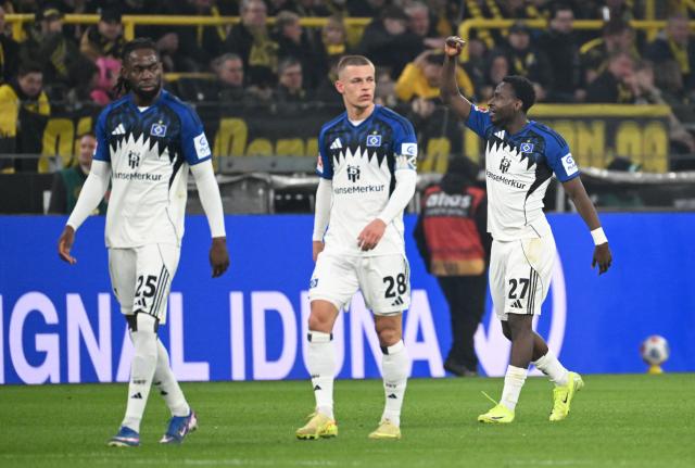 Hamburg's Nigerian froward #27 Philip Otele (R) celebrates his 0-1 during the German first division Bundesliga football match between Borussia Dortmund and HSV Hamburg in Dortmund, western Germany, on March 21, 2026. (Photo by UWE KRAFT / AFP) / DFL REGULATIONS PROHIBIT ANY USE OF PHOTOGRAPHS AS IMAGE SEQUENCES AND/OR QUASI-VIDEO