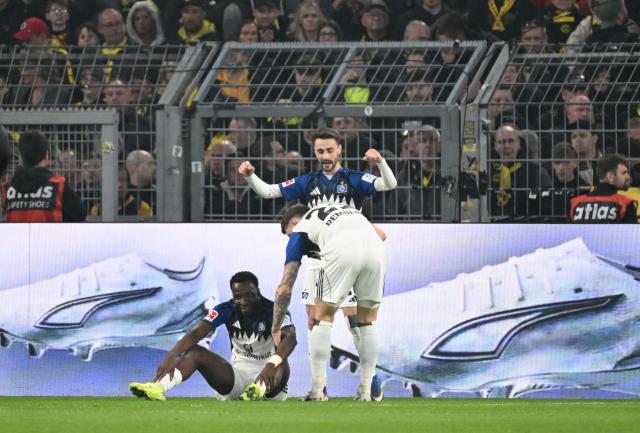 Hamburg's Nigerian froward #27 Philip Otele (L) celebrates his 0-1 during the German first division Bundesliga football match between Borussia Dortmund and HSV Hamburg in Dortmund, western Germany, on March 21, 2026. (Photo by UWE KRAFT / AFP) / DFL REGULATIONS PROHIBIT ANY USE OF PHOTOGRAPHS AS IMAGE SEQUENCES AND/OR QUASI-VIDEO