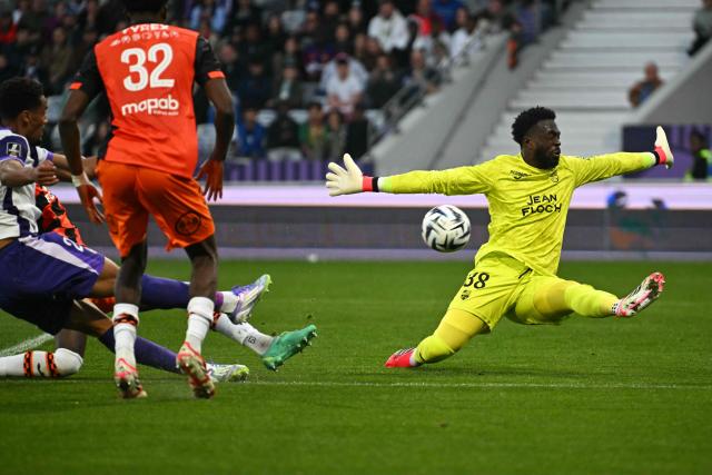 Toulouse’s Brazilian forward #20  Emersonn (L)  shoots and scores a goal past Lorient Swiss goalkeper #38 Yvon Mvogo during the French L1 football match between Toulouse FC and FC Lorient at the Stadium in Toulouse, on March 21, 2026. (Photo by Lionel BONAVENTURE / AFP)