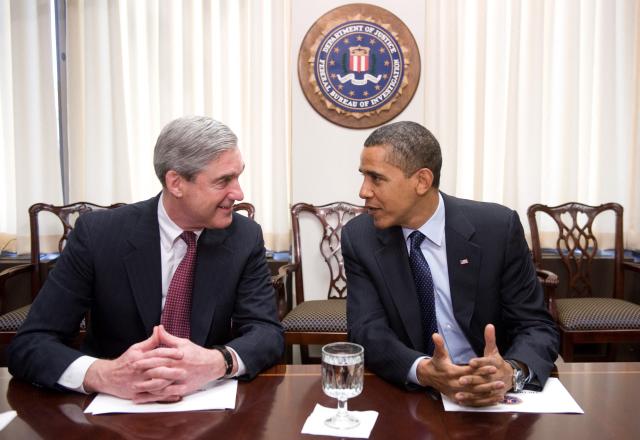 (FILES) US President Barack Obama speaks with FBI Director Robert Mueller during a meeting at FBI Headquarters in Washington, DC, April 28, 2009. Mueller, the former FBI director who led a politically explosive investigation into President Donald Trump, has died aged 81, US media reported on March 21, 2026. (Photo by Saul LOEB / AFP)