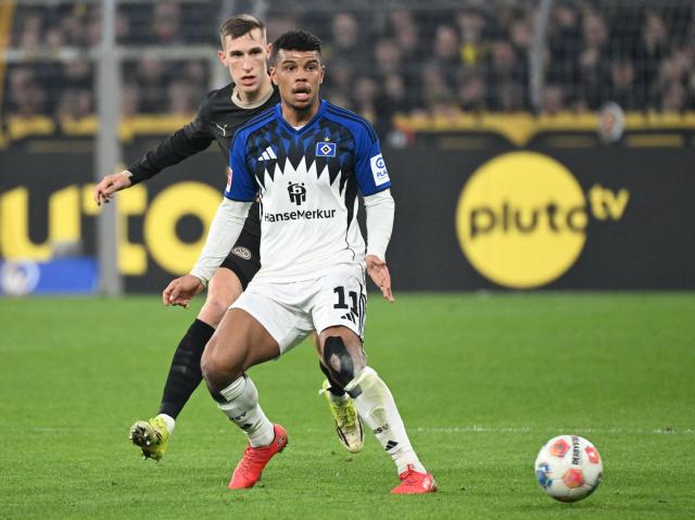Dortmund's German defender #04 Nico Schlotterbeck (L) and Hamburg's Ghanaian forward #11 Ransford Konigsdorffer vie for the ball during the German first division Bundesliga football match between Borussia Dortmund and HSV Hamburg in Dortmund, western Germany, on March 21, 2026. (Photo by UWE KRAFT / AFP) / DFL REGULATIONS PROHIBIT ANY USE OF PHOTOGRAPHS AS IMAGE SEQUENCES AND/OR QUASI-VIDEO