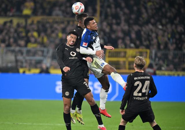 Hamburg's Ghanaian forward #11 Ransford Konigsdorffer (Top R) vies for the ball during the German first division Bundesliga football match between Borussia Dortmund and HSV Hamburg in Dortmund, western Germany, on March 21, 2026. (Photo by UWE KRAFT / AFP) / DFL REGULATIONS PROHIBIT ANY USE OF PHOTOGRAPHS AS IMAGE SEQUENCES AND/OR QUASI-VIDEO