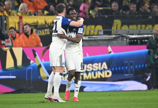 Hamburg's Belgian-Congolese midfielder #06 Albert Sambi Lokonga (R) celebrates his 0-2 during the German first division Bundesliga football match between Borussia Dortmund and HSV Hamburg in Dortmund, western Germany, on March 21, 2026. (Photo by UWE KRAFT / AFP) / DFL REGULATIONS PROHIBIT ANY USE OF PHOTOGRAPHS AS IMAGE SEQUENCES AND/OR QUASI-VIDEO