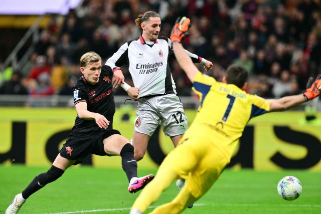 AC Milan's French midfielder  #12 Adrien Rabiot scores his team's second goal against Torino's Italian goalkeeper #01 Alberto Paleari during the Italian Serie A football match between AC Milan and Torino at San Siro stadium in Milan, northern Italy, on March 21, 2026. (Photo by Stefano RELLANDINI / AFP)