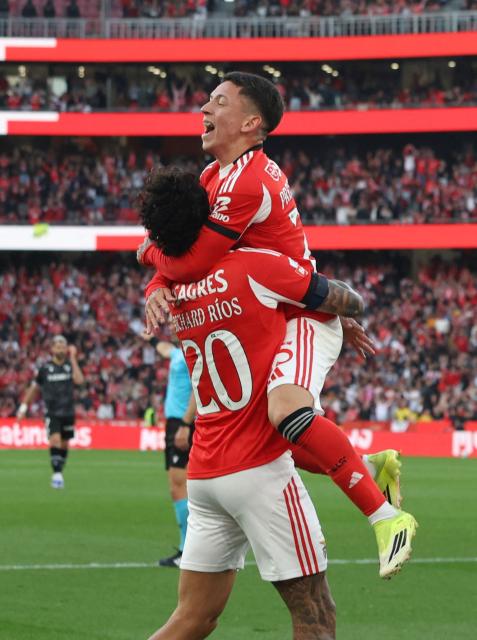 SL Benfica's Argentine forward #25 Gianluca Prestianni celebrates scoring his team's first goal with SL Benfica's Colombian midfielder #20 Richard Rios during the Portuguese League football match between SL Benfica and Vitoria Guimaraes at Estadio da Luz in Lisbon on March 21, 2026. (Photo by Henrique Casinhas / AFP)