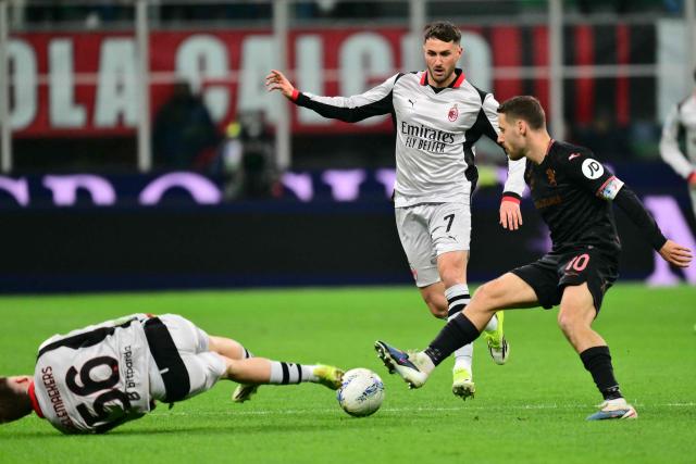 AC Milan's Mexican forward #07 Santiago Gimenez and AC Milan's Belgian midfielder #56 Alexis Saelemaekers fights for the ball with Torino's Croatian midfielder #10 Nikola Vlasic during the Italian Serie A football match between AC Milan and Torino at San Siro stadium in Milan, northern Italy, on March 21, 2026. (Photo by Stefano RELLANDINI / AFP)